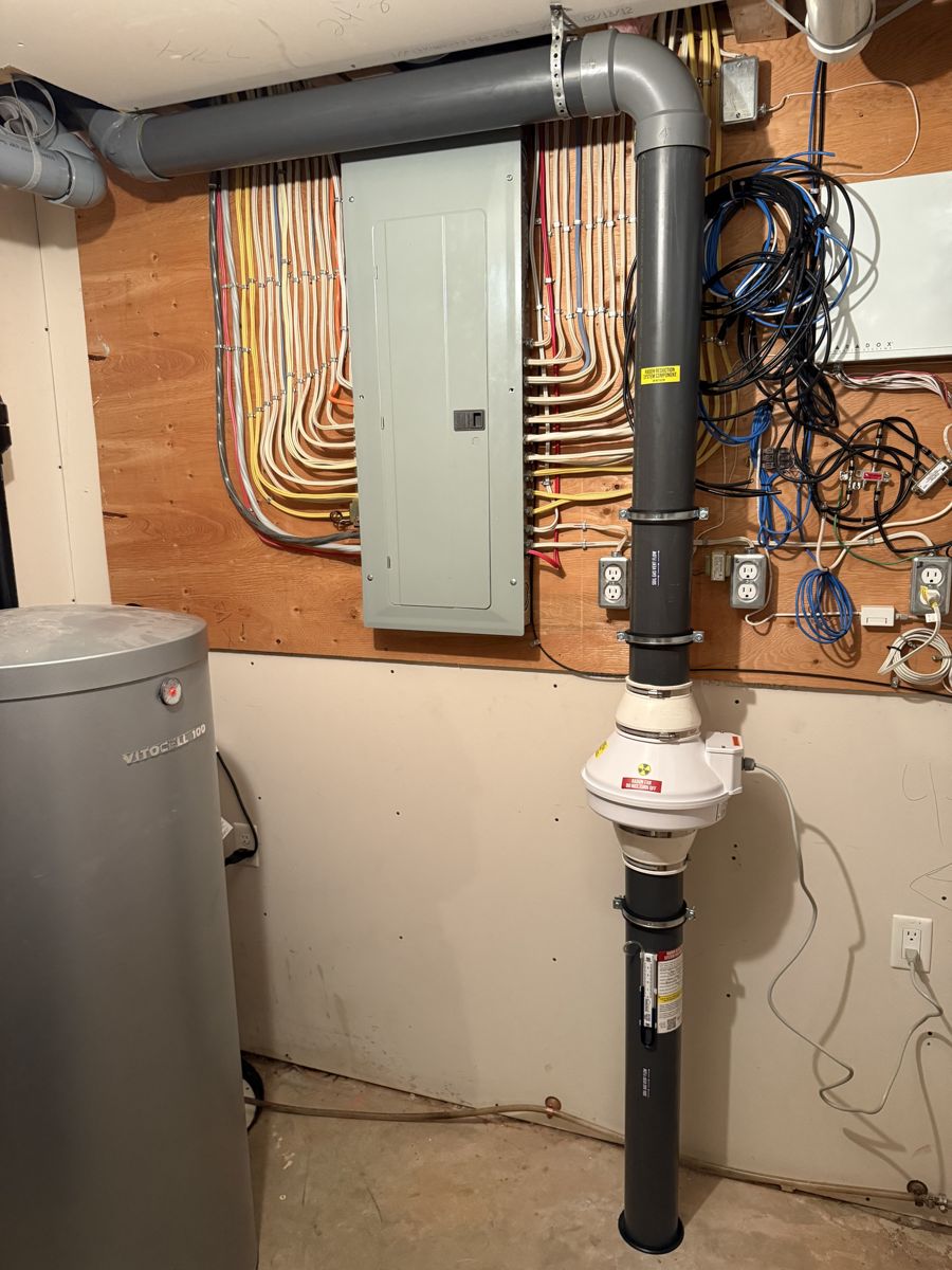 Radon system routed neatly beside an electrical panel