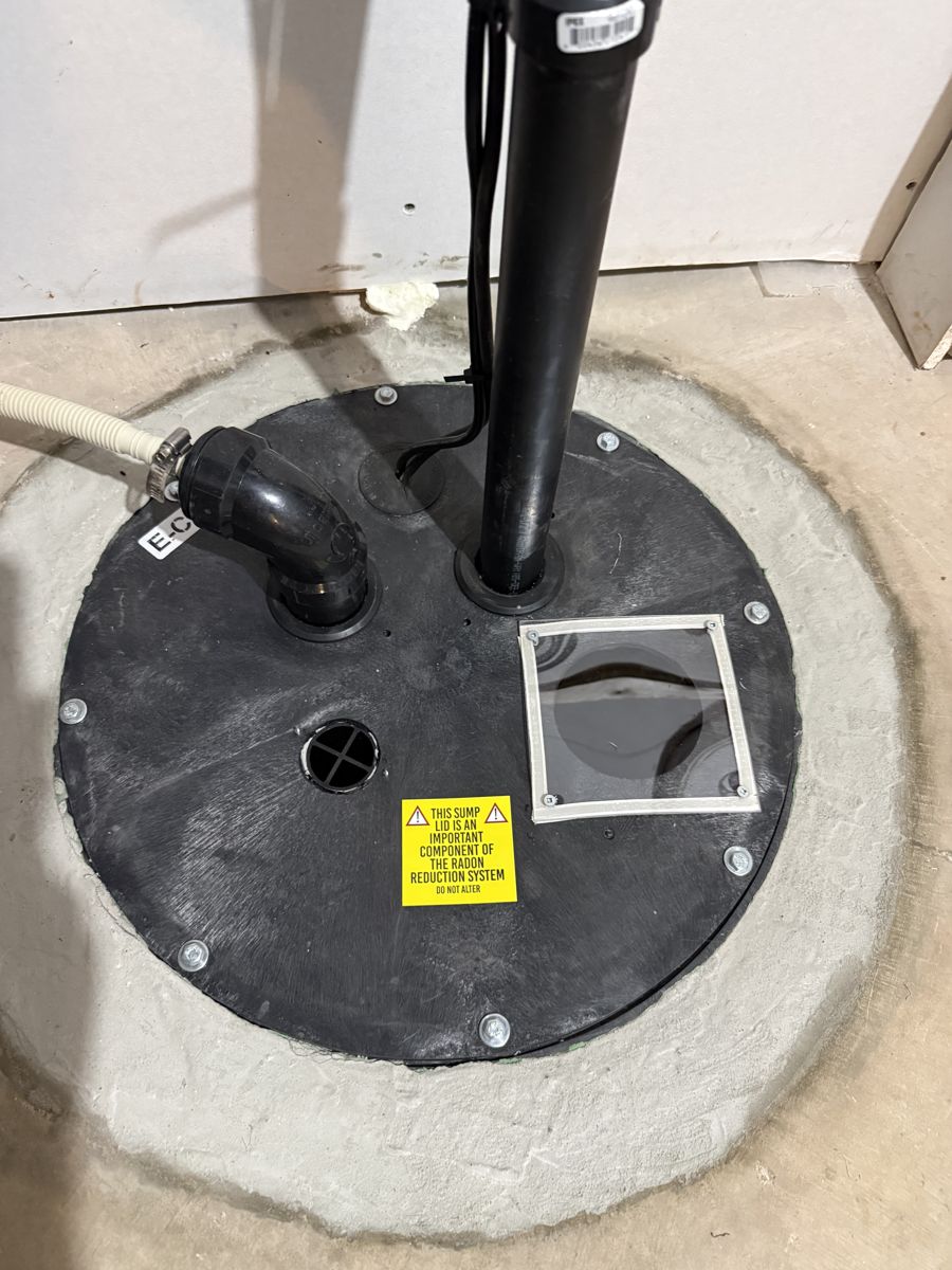 Airtight sump lid with a one-way valve, service viewport and radon system warning label